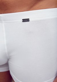 Vita bomullsboxer med ribbat mönster och en Jockey-logotags, med en åtsittande passform och midjehögt linning.