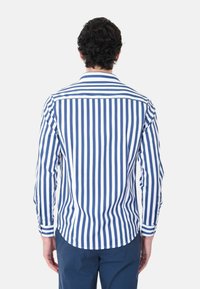 Camicia a maniche lunghe blu e bianca a strisce con orlo curvo e polsini con bottone, realizzata in un tessuto leggero.
