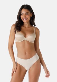 Reggiseno imbottito nudo con spalline regolabili e design senza cuciture, abbinato a slip bikini a vita alta coordinati, caratterizzati da una texture liscia e morbida.