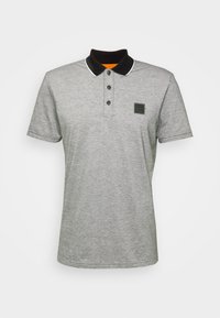 Polo gris clair à manches courtes avec col noir, bordure blanche, trois boutons et petit écusson noir avec logo sur la poitrine gauche.