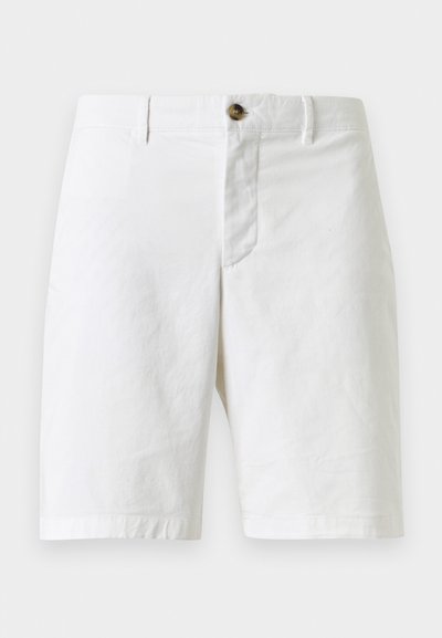 Short blanc longueur genou avec passants de ceinture, fermeture éclair devant et un bouton marron unique, présenté sur un fond uni.