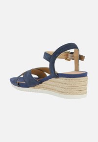 Sandalia cuña de color azul marino con suela de yute trenzado, dos correas frontales, correa para el tobillo con hebilla y forro de la plantilla en color beige.