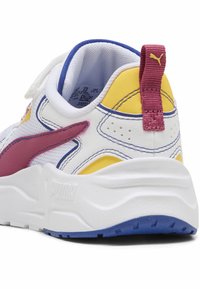 Sneaker bianca con collo imbottito, dettagli gialli e rosa, materiale testurizzato, suola bianca spessa, suola viola e dettagli di cucitura a contrasto.