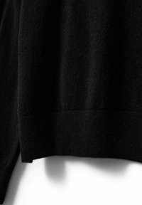 Melnā adīta džemperis ar mīkstu tekstūru, izceļoties ar ribotām malām un gludu apdari. Tuvplāns attēls izceļ auduma detaļas.