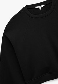 Czarny skrócony sweatshirt wykonany z miękkiego materiału, z okrągłym dekoltem, rękawami raglanowymi oraz ściągaczami na mankietach i dolnej krawędzi. Brak wzorów i akcentów.