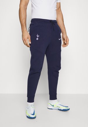 Donkerblauwe Nike joggingbroek met trekkoord in de taille, voorzien van een Spurs-logo in paars, taps toelopende pasvorm en textuurdetails in de stof.