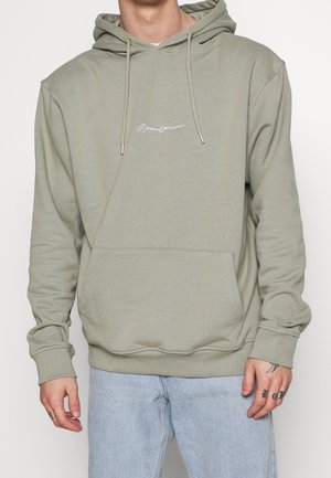 Olijfgroene katoenen hoodie. Voorzien van een voorzak, trekkoorden en een wit geborduurd logo op de borst.