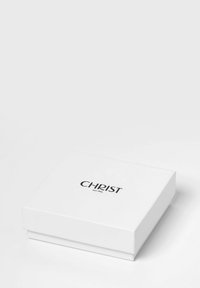 Weißer Geschenkkarton mit glatter Oberfläche, auf dem sich ein schwarzes Logo mit der Aufschrift "CHRIST est. 1863" zentriert auf der Oberseite befindet. Quadratische Form, minimalistisches Design.