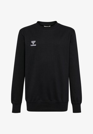 Deux enfants debout, portant des sweats noirs assortis, des joggings noirs et des baskets noires sur un fond clair.