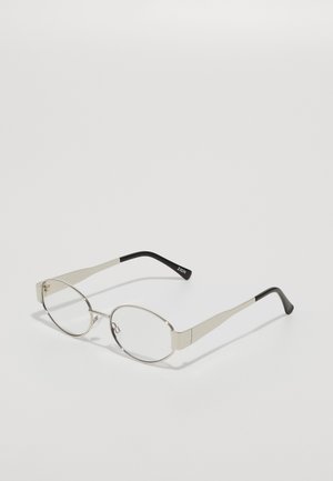 Óculos de metal com lentes ovais, armação fina prateada e hastes prateadas afiladas. Pontas em plástico preto nas hastes com detalhe da marca.
