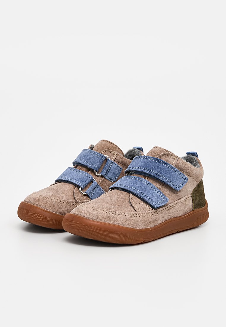Zapatos con tiras de Velcro hechos de ante marrón claro con correas azules y acentos verdes. Cuentan con una suela de goma para agarre y estabilidad.