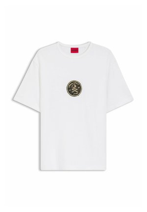 Hvid T-shirt med korte ærmer, rund halsudskæring og lille sort og guldfarvet dødningehoved- og benkryds-badge centreret på brystet.