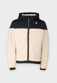 Fleece-vuorattu takki, jossa on musta nylonosa ja kermahuppua. Varustettu hupulla, vetoketjulla ja elastisilla hihansuihilla. Mukana logo rinnassa.