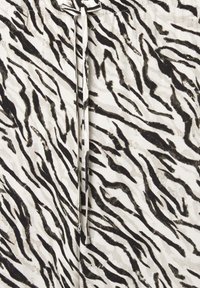 Zebra print stof in zwart-wit met een zachte textuur; heeft een trekkoord in de taille.