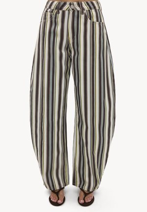 Pantalon à jambes larges avec des rayures verticales dans des tons marron, crème et bleu clair, porté avec des tongs noires et des orteils visibles.