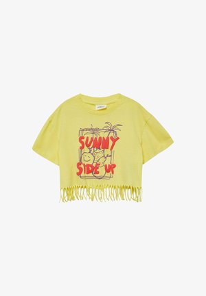 Żółty krótki T-shirt z frędzlami przy brzegu, czerwony napis „SUNNY SIDE UP” oraz fioletowa linia rysunku uśmiechniętych owoców i palm.