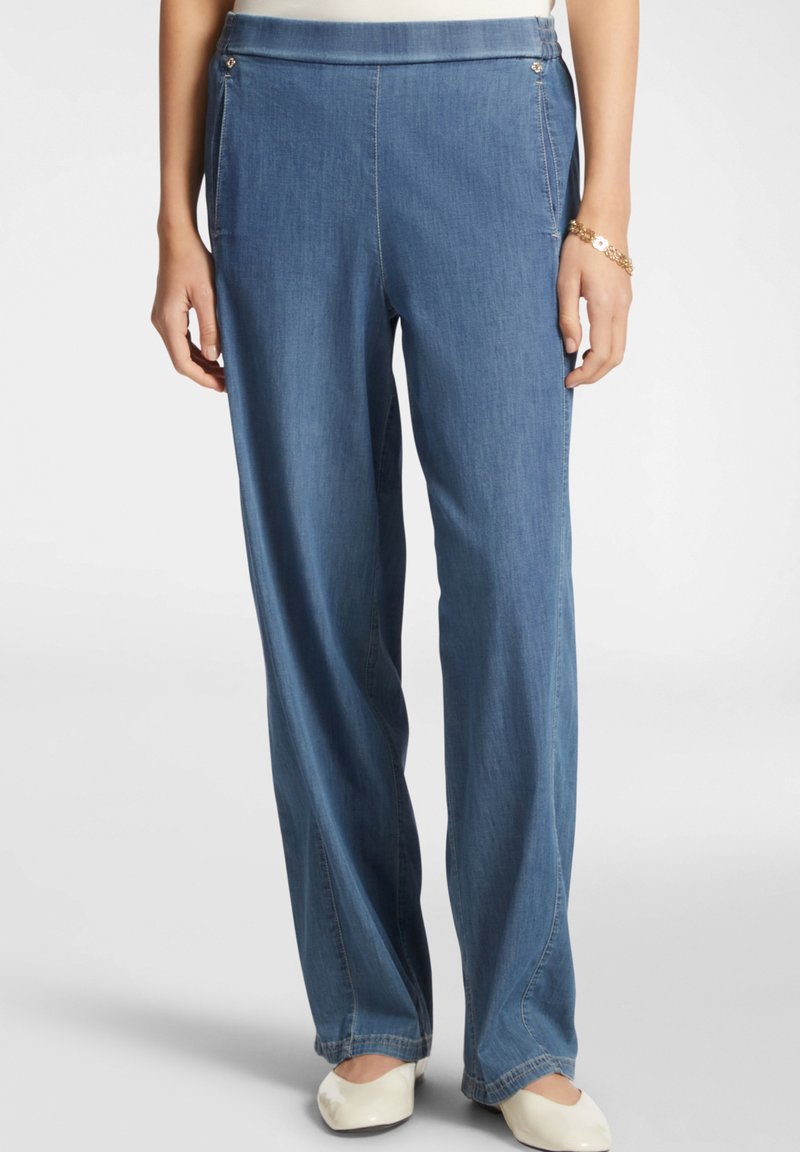 Pantaloni in denim azzurro chiaro con taglio dritto, dotati di tasche frontali e dettagli in metallo decorativi. Texture liscia, vita standard.