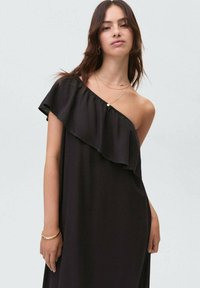 Abito nero a spalla singola realizzato in tessuto morbido, con scollatura arricciata, vestibilità ampia e design minimal.
