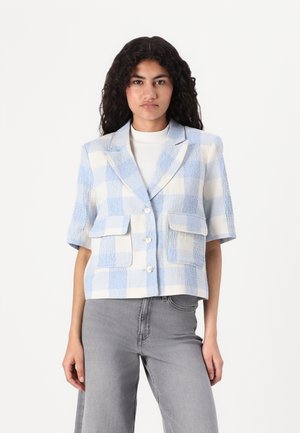 Blazer à manches courtes à carreaux en bleu clair et crème, avec un tissu texturé, deux poches avant et un bouton de fermeture.