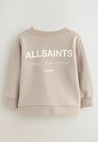 Felpa beige con polsini e orlo a costine. Presenta testo bianco: "ALLSAINTS," caratteri giapponesi e "LONDON." Materiale morbido e vestibilità comoda.