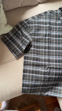 Kortsleeved skjorte i mørkegrå rutet design med hvite og lyseblå linjer. Laget av lett stoff med en jevn tekstur.