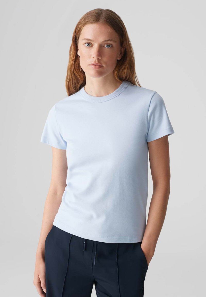 Helles blaues T-Shirt mit kurzen Ärmeln aus Baumwolle, mit Rundhalsausschnitt, glatter Textur und tailliertem Schnitt.