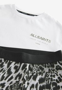 Hvid T-shirt med sort dyreprint i den nederste halvdel. Har "ALLSAINTS" logo i metallisk detalje og en sort elastik med præget branding.