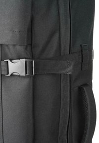 Mochila de tela negra con un cinturón lateral, material texturizado y detalles de correa complementarios. Diseñada para la durabilidad y la funcionalidad.