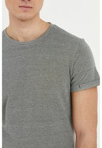Tricou gri cu mânecă scurtă, guler rotund, țesătură texturată cu un subtil model heather, cu manșete rulate și un design ajustat.