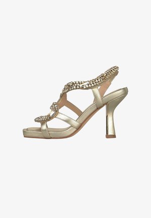 Sandalia dorada de tacón alto con diseño de tira en T, adornada con brillantes transparentes y un tacón ancho curvado.