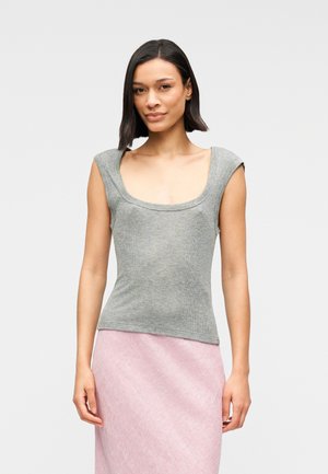 Débardeur gris côtelé avec un large décolleté en U et des manches courtes, silhouette ajustée. Associé à une jupe texturée rose clair.