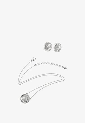 Ezüst nyaklánc kör alakú medállal, részletes kidolgozással. Hozzá illő kör alakú fülbevalóval párosítva, mindkettő texturált felülettel.