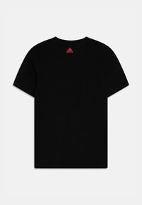 Camiseta de algodón negra con mangas cortas. Presenta un logo de Adidas en rojo impreso en la parte trasera, cerca del cuello. Diseño sencillo y limpio.