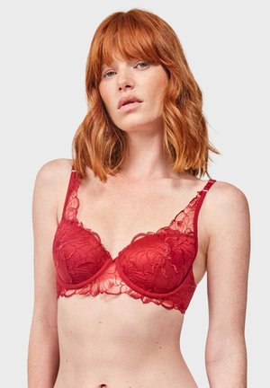Soutien-gorge en dentelle rouge avec armatures, motif floral, bretelles réglables et bords festonnés, améliorant la structure et le détail de conception.