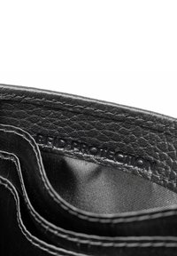 Interior de una billetera de cuero negro con etiqueta de protección RFID, que presenta múltiples ranuras para tarjetas y forro texturizado. Diseño simple y funcional.