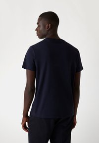 Navyblauwe katoenen T-shirt met korte mouwen, ronde hals en een eenvoudige, gladde textuur. Geen zichtbare logo's of patronen.