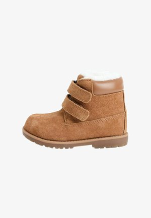Stivale alla caviglia in suede marrone con due fasce in Velcro, fodera in pile bianco, collare in pelle imbottita e suola in gomma con battistrada.