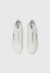 White athletic shoes featuring a textured upper, sleek design, and perforated detailing. Elastic laces and brand logo on the tongue.