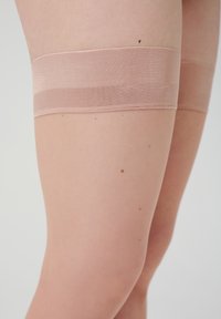 Huidskleurige bovenbenkousen met een gestructureerde beige band, een gladde stof en een aansluitend ontwerp, tot halverwege de dij.
