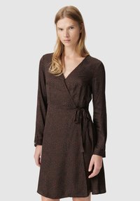Bruine wikkeljurk met een subtiele dierenprint, lange mouwen, een V-halslijn en een taillebanddetail. Gladde textuur en casual pasvorm.