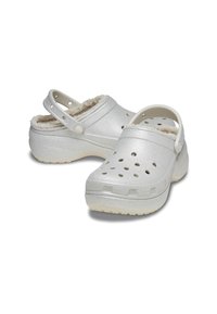 Silberne Holzschuhe mit einer strukturierten, glänzenden Oberfläche. Versehen mit einem weichen Futter aus Fleece und einem verstellbaren Riemen an der Rückseite für einen sicheren Sitz.