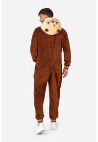 Tutina marrone in morbido peluche con un cappuccio a forma di animale color sabbia, caratterizzato da occhi e bocca in stile cartone animato. Inclusa la coda e polsini elasticizzati.