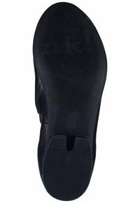 Semelle de chaussure noire en caoutchouc avec un motif de grip texturé et une rainure centrale. Marquage visible. Bords lisses avec une légère courbure pour le confort.
