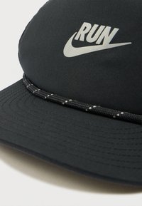 Μαύρο καπέλο από ύφασμα με κυρτή γείσο, λογότυπο "RUN" σε ασημί και υφασμάτινη ταινία γύρω από τη βάση της γείσος.