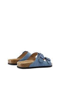 Sandali blu in suede con due cinturini regolabili, sottopiede in sughero e suola in gomma nera texturizzata. Design aperto con lati sagomati.