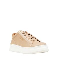 Sneaker beige in pelle con suola bianca spessa, allacciatura frontale e dettaglio in occhio dorato sul lato.