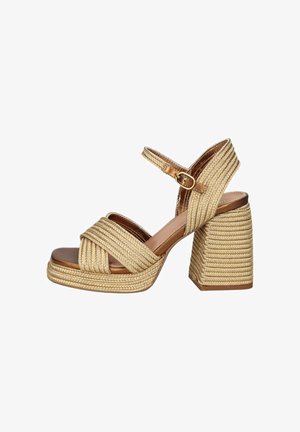 Sandalo beige con tacco a blocco intrecciato, cinturini incrociati, cinturino alla caviglia con fibbia dorata e suola con plateau.