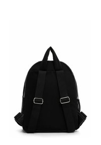 Černý batoh s nastavitelnými ramenními popruhy, horním madlem a viditelnými bočními zipy, zobrazený zezadu na bílém pozadí.