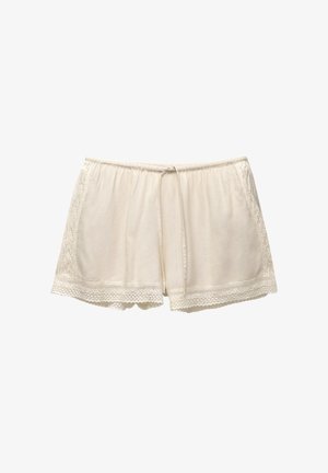 Cream-colored shorts made of soft fabric, featuring lace trim along the edges and a drawstring waistband.