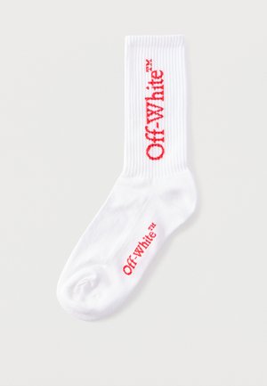 Biała skarpeta załogowa z czerwonym logo "Off-White™" umieszczonym pionowo na łydce i poziomo przy palcach na jednolitym tle.